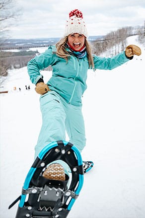 woman kicking up her snowshoe