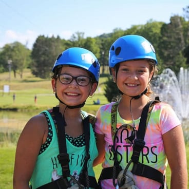 girl ziplining through the trees