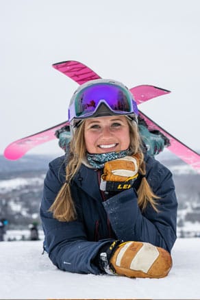 girl on belly on snow with skis crossed